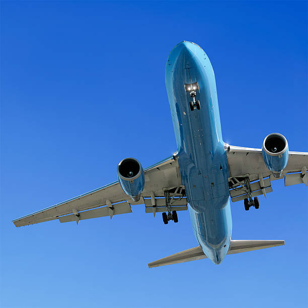 istock jet airplane landing in clear blue sky 90407875