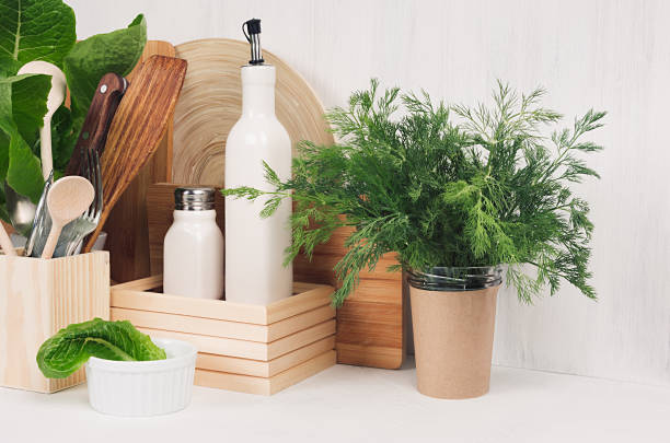 istock White modern kitchen decor with beige rustic wooden utensils, fresh green spinach, dill in pot on wood background. 904079114