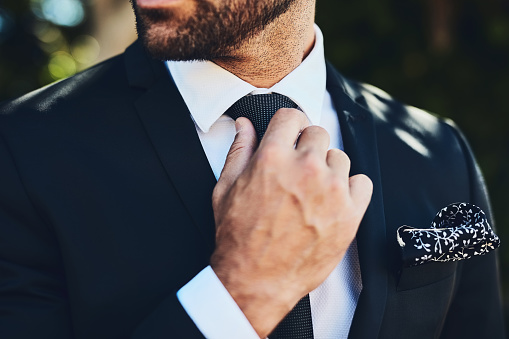 Cropped shot of an unrecognizable man adjusting his tie outside