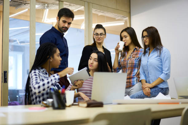 istock Crew of young graphic designers creating main concepts for new office building and making research on digital tablet connected to 4G internet,male and female having informal meeting during conference 904082570