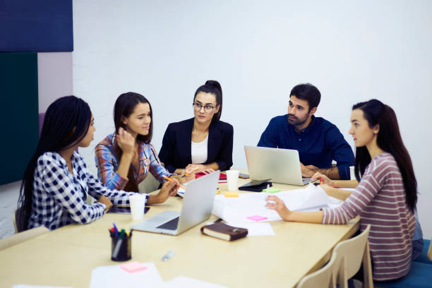 istock Group of professional marketing experts having brainstorming session creating advertising campaign consulting with executive manager supervising working process and discussion at meeting table 904082578