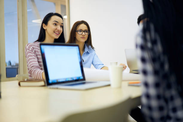 istock Talented group of students having consultancy in friendly atmosphere and browsing information on laptop computer with mock up screen connected to wireless internet sitting in coworking office 904082684