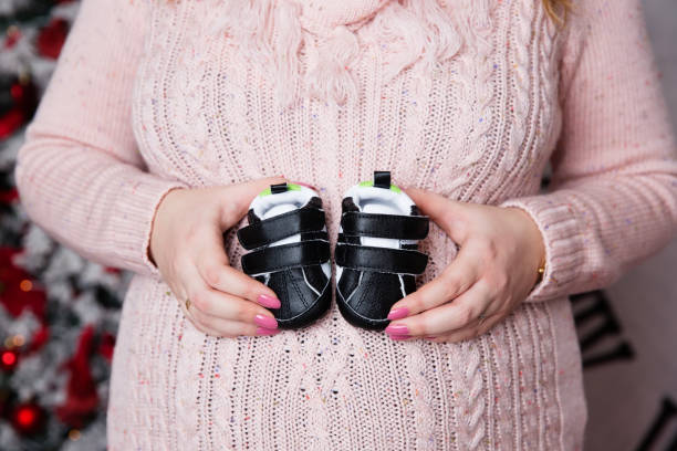 istock Pregnant belly with newborn baby booties 904083926