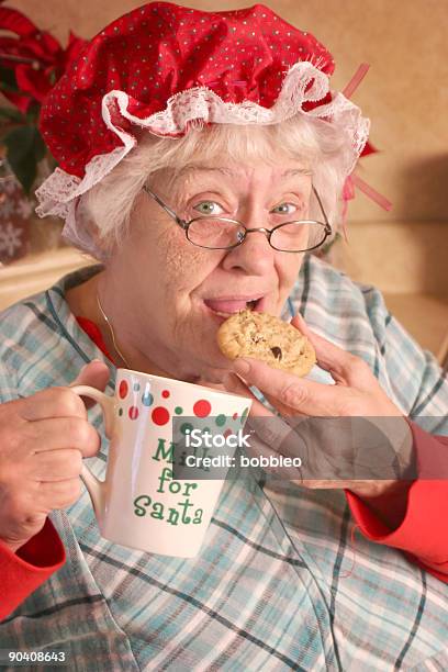 La Sra Cláusula Sneaking Las Cookies Foto de stock y más banco de imágenes de Abuela - Abuela, Taza sin platillo, 70-79 años