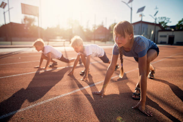 bambini che si preparano per la gara di corsa su pista - school sports foto e immagini stock