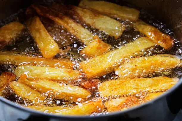 Photo of French fries fry in hot bubbling oil