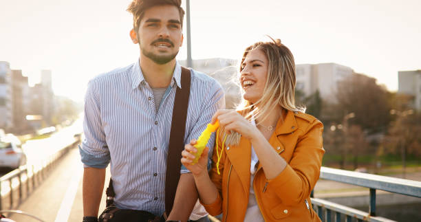 istock Beautiful young couple blowing soap bubbles and smiling 904102872