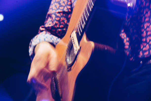 istock closeup rockstar on stage playing on electro guitar. Male guitarist 904106576