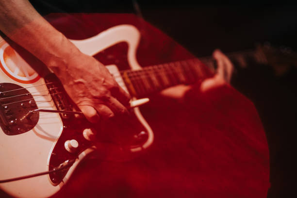 istock closeup rockstar on stage playing on electro guitar. Male guitarist 904106690