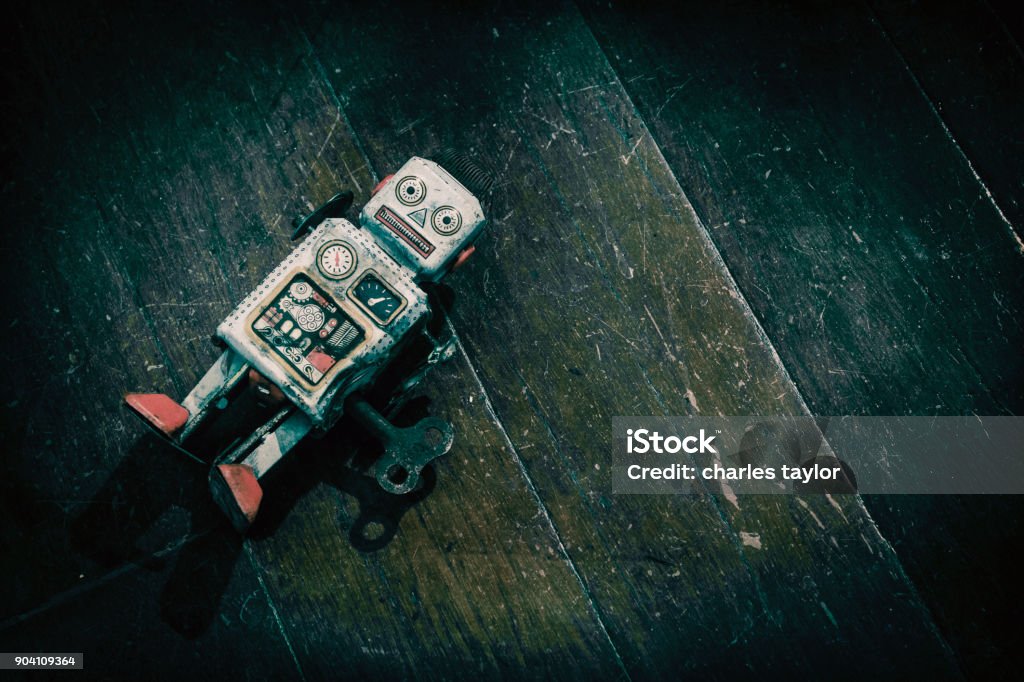 triste beat up antiguo retro robot sobre un suelo de madera - Foto de stock de Robot libre de derechos