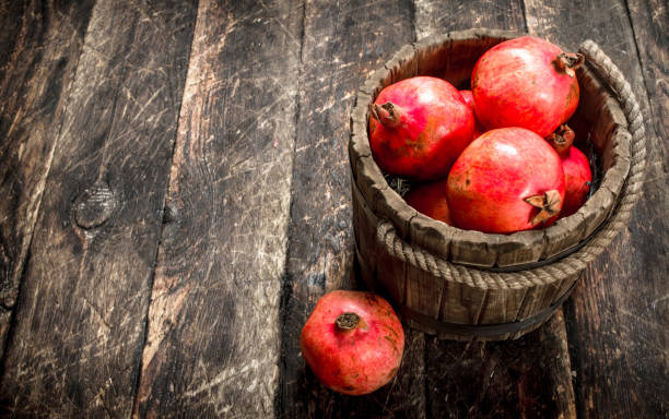 istock Fresh pomegranates in wooden bucket. 904113644