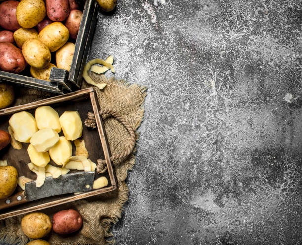 istock Peeled potatoes on a wooden board. 904114282