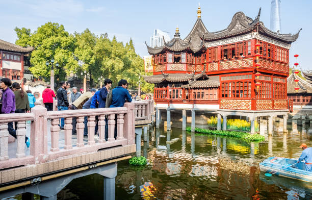 Shanghai, China - Nov 4, 2016: Around Yu Yuan (Yu Garden) – Old building with architectural structures in traditional Chinese styling converted to modern-day teahouse. Busy scene filled with masses of visitors on stone bridge.