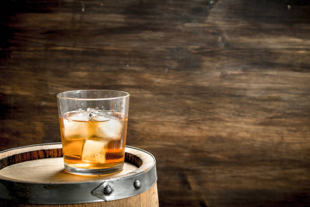 istock glass of Scotch whiskey with a barrel. 904123380