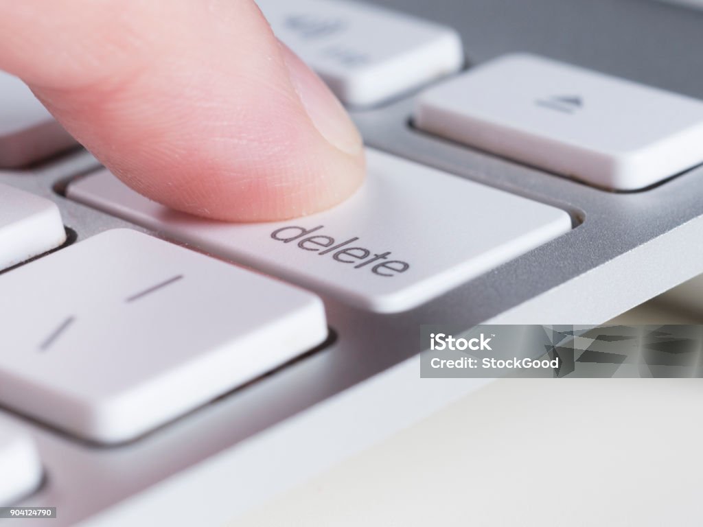 Finger is pressing delete key of computer keyboard Finger is pressing delete key of computer keyboard. Delete Key Stock Photo