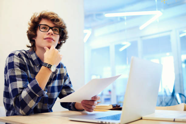 istock Talented young male journalist reading press release for official event thinking over creative post announcement in social networks inviting students to take part in working in office with free wifi 904127706
