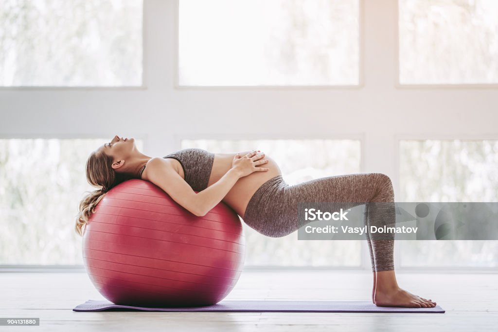 Pregnant woman workout. Beautiful pregnant woman workout. Doing yoga with fitball. Pregnant Stock Photo