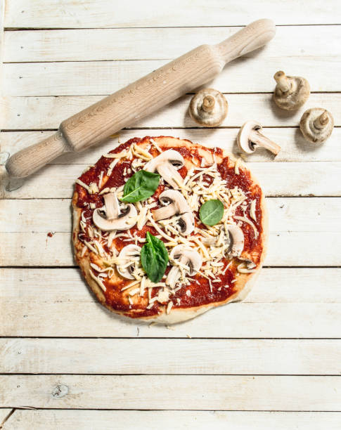 istock Preparation of pizza with various ingredients. 904136946