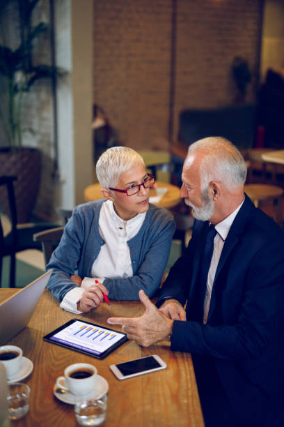 istock Senior business people using digital tablet in cafe. 904136948