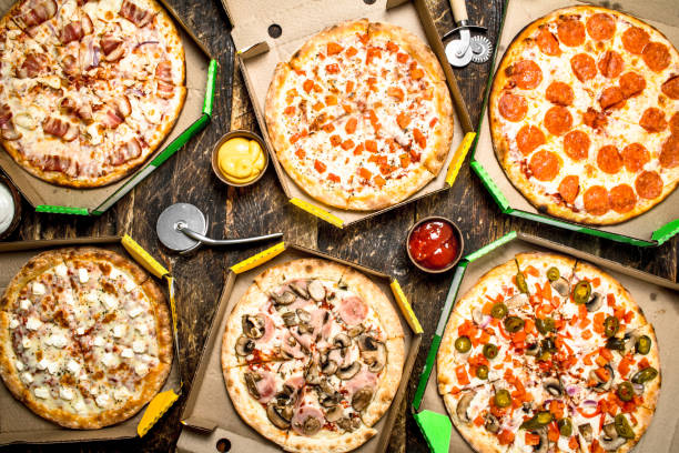 Fresh pizza in boxes. Fresh pizza in boxes. On a wooden background. hot mix plant stock pictures, royalty-free photos & images