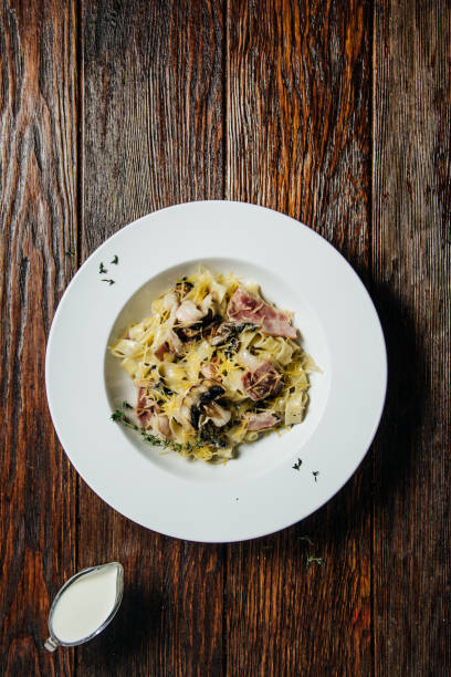 istock Pasta spaghetti with creamy mushroom sauce in white ceramic plate over old grunge dark table. 904138070
