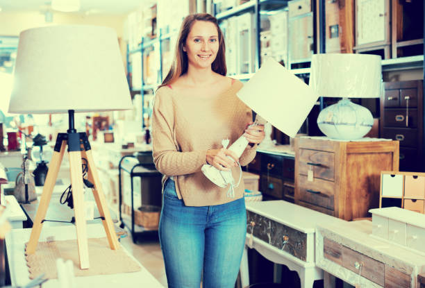 istock Young woman choosing table lamp 904141998