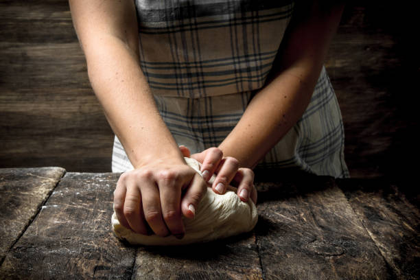 istock Dough background. A woman is preparing a dough. 904145734