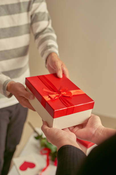 istock Hands giving and receiving a red present 904146338