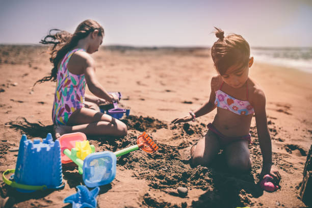 istock Young girls having fun playing with toys on beach sand 904150740
