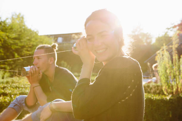 istock cans communication: young woman listens into tin can phone 904150790