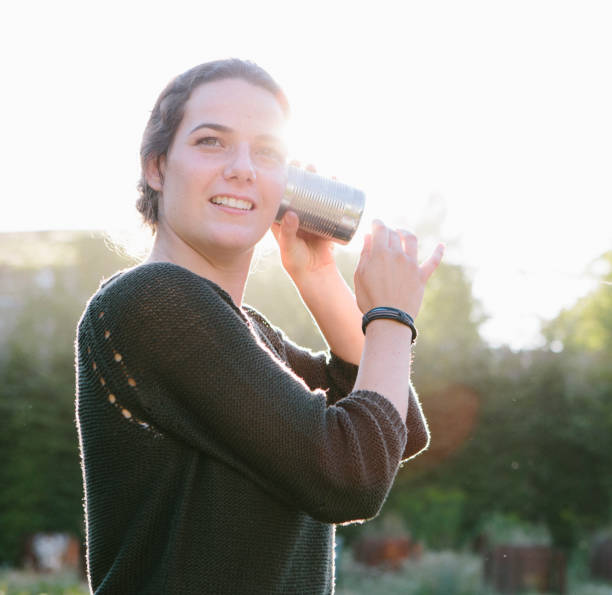 istock cans communication: young woman listens into tin can phone 904151126