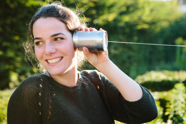 istock cans communication: young woman listens into tin can phone 904153192