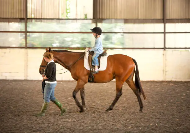 A nervous young girl being taken on her first riding lesson