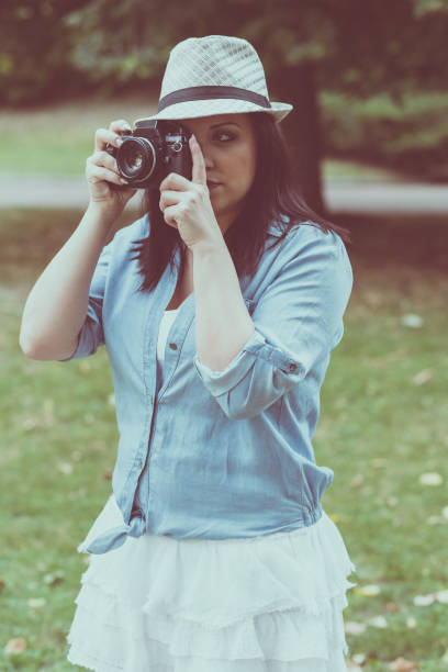 istock Portrait of pretty young woman using a camera 904166856
