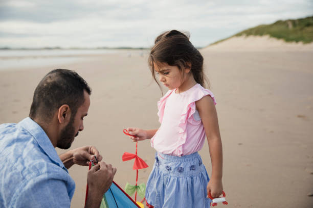 istock Father and Daughter Playing On The Beach With a Kite 904169136