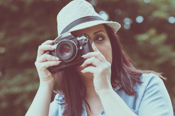 istock Portrait of pretty young woman using a camera 904171174