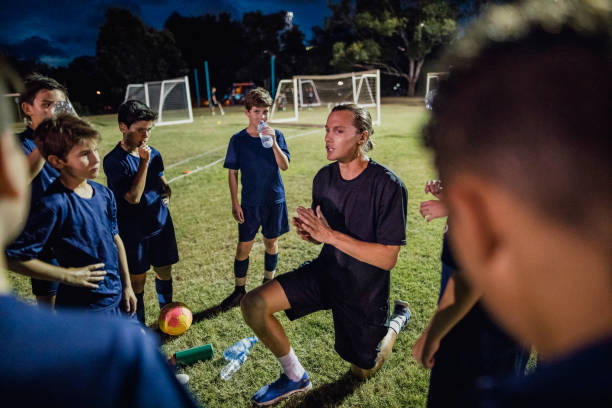 Soccer Team Meeting Soccer coach talking to the team. sports training drill stock pictures, royalty-free photos & images