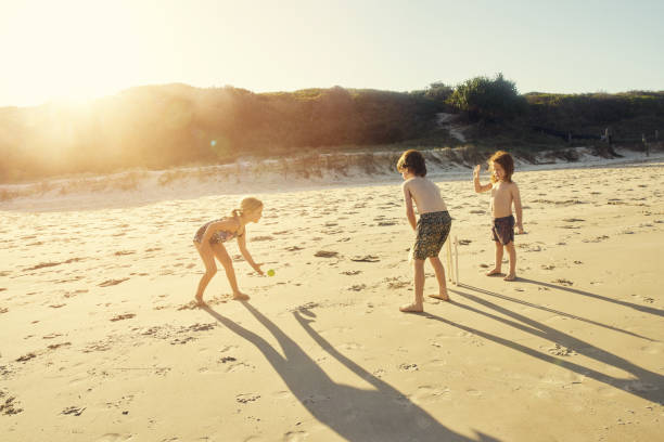 Group of children having fun playing bucket in the sand of the beautiful beach in Algarve Portugal