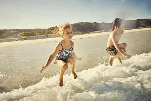 Shot of an adorable brother and sister having fun in the water at the beach