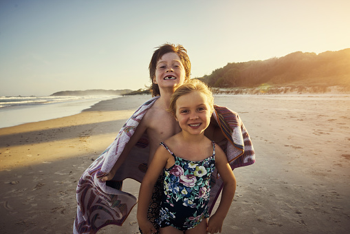 Shot of a happy brother and sister enjoying a day at the beach