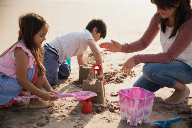 istock Mother and Children Playing On The Beach 904178544
