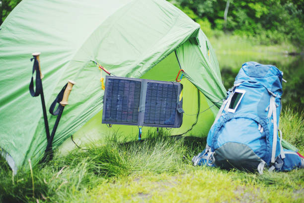 istock Camping on the river bank. The solar panel hangs on the tent. 904185064
