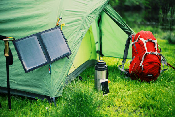 istock Camping on the river bank. The solar panel hangs on the tent. 904186074