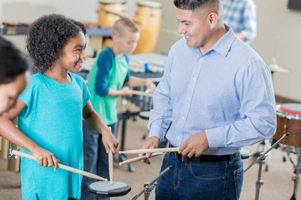 istock Excited girl enjoys learning to play drums 904190828
