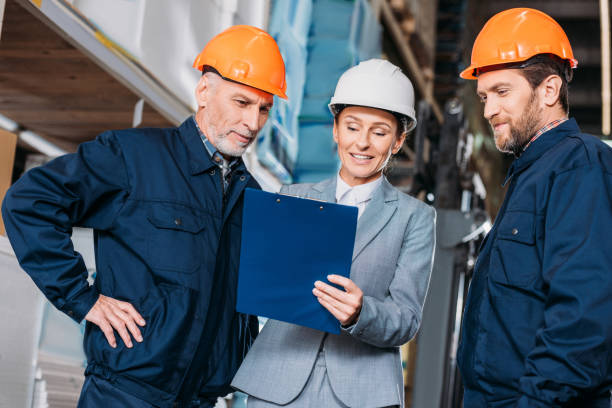 istock male workers and female inspector in helmets in warehouse 904191228