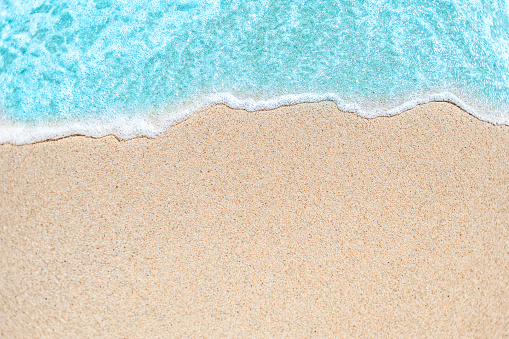 Imagen de fondo de suave onda de océano azul en la playa de arena.  Onda del océano de cerca con espacio de copia de texto 
