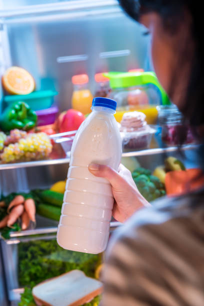 istock Woman takes the milk from the open refrigerator 904207882