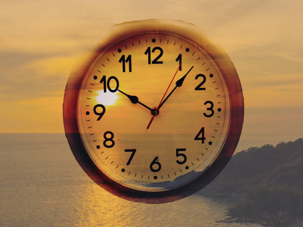istock clock against golden sunrise at sea. Double exposure 904210496