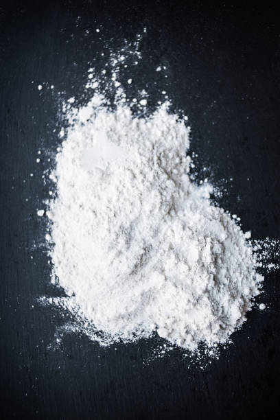 istock White Flour powder on black background as dust splash clouds. Baking preparation, top view. Cooking recipe concept