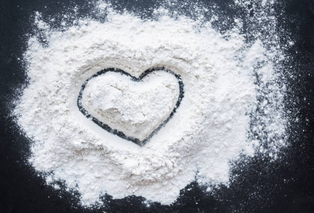 istock Valentine Day Concept idea image - Heart shape in a baking flour on black background. Cooking love recipe concept 904211982